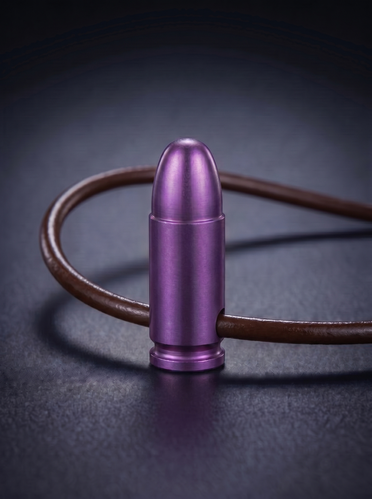 Magenta titanium pistol cartridge pendant on brown leather cord