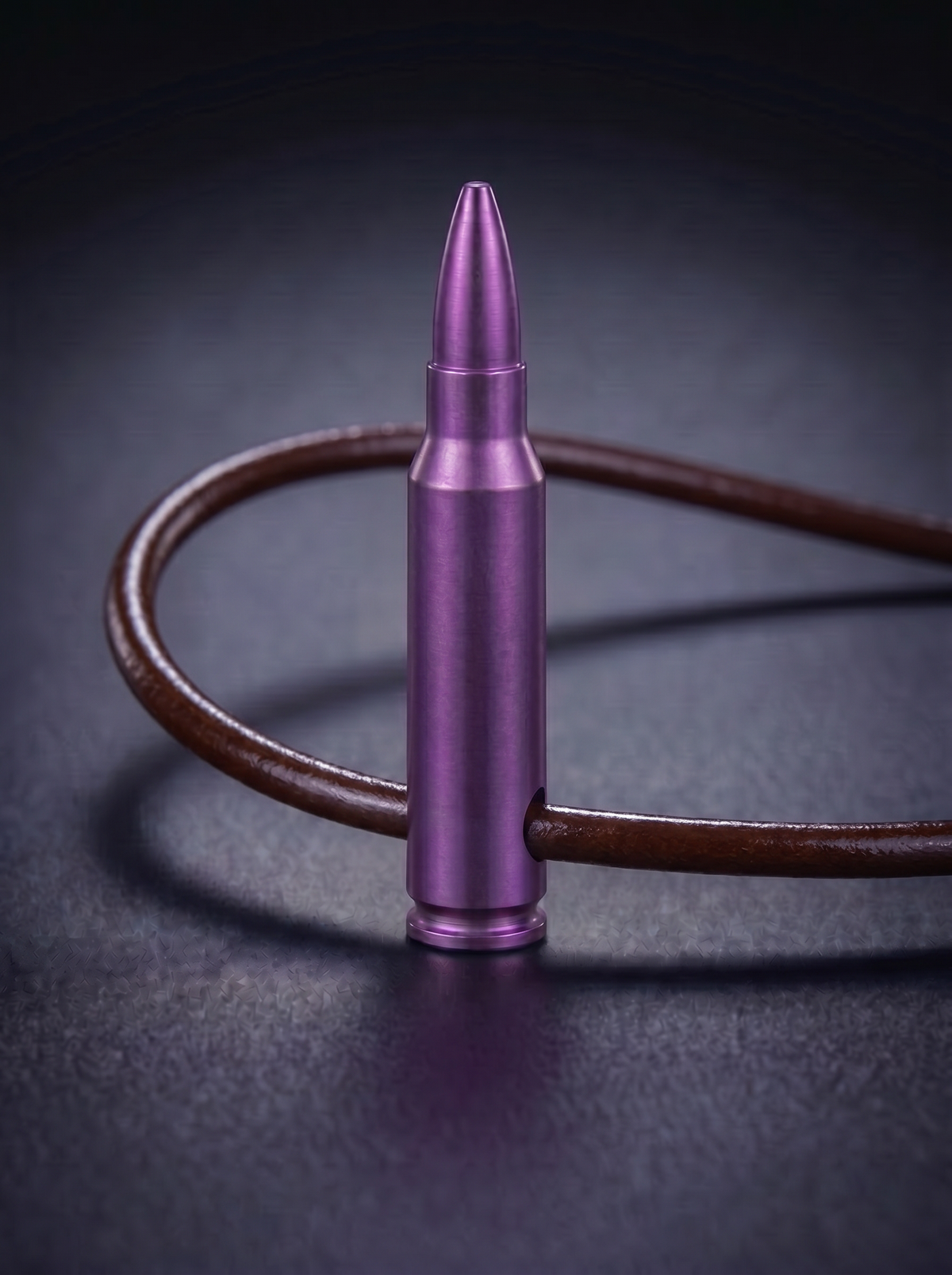 Magenta titanium rifle cartridge pendant on brown leather cord