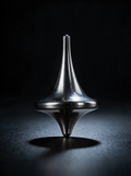 Polished grade-5 titanium spinning top, The Totem, upright on a dark surface