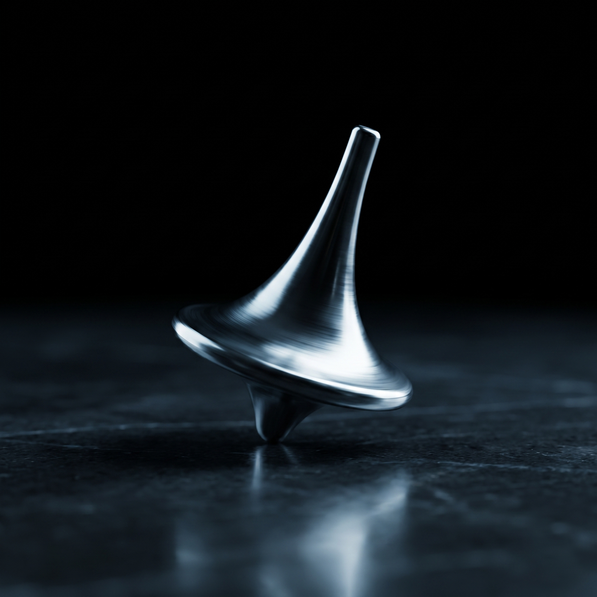 The Totem mid-spin on a desk, polished titanium